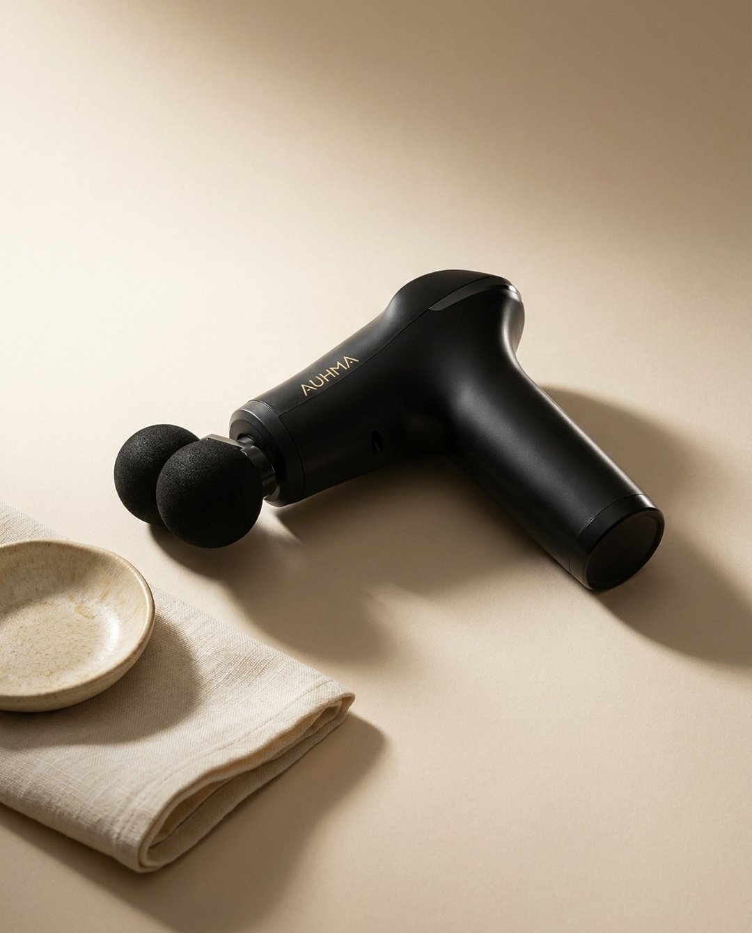 Auhma Massage Gun — composition éditoriale lin et céramique